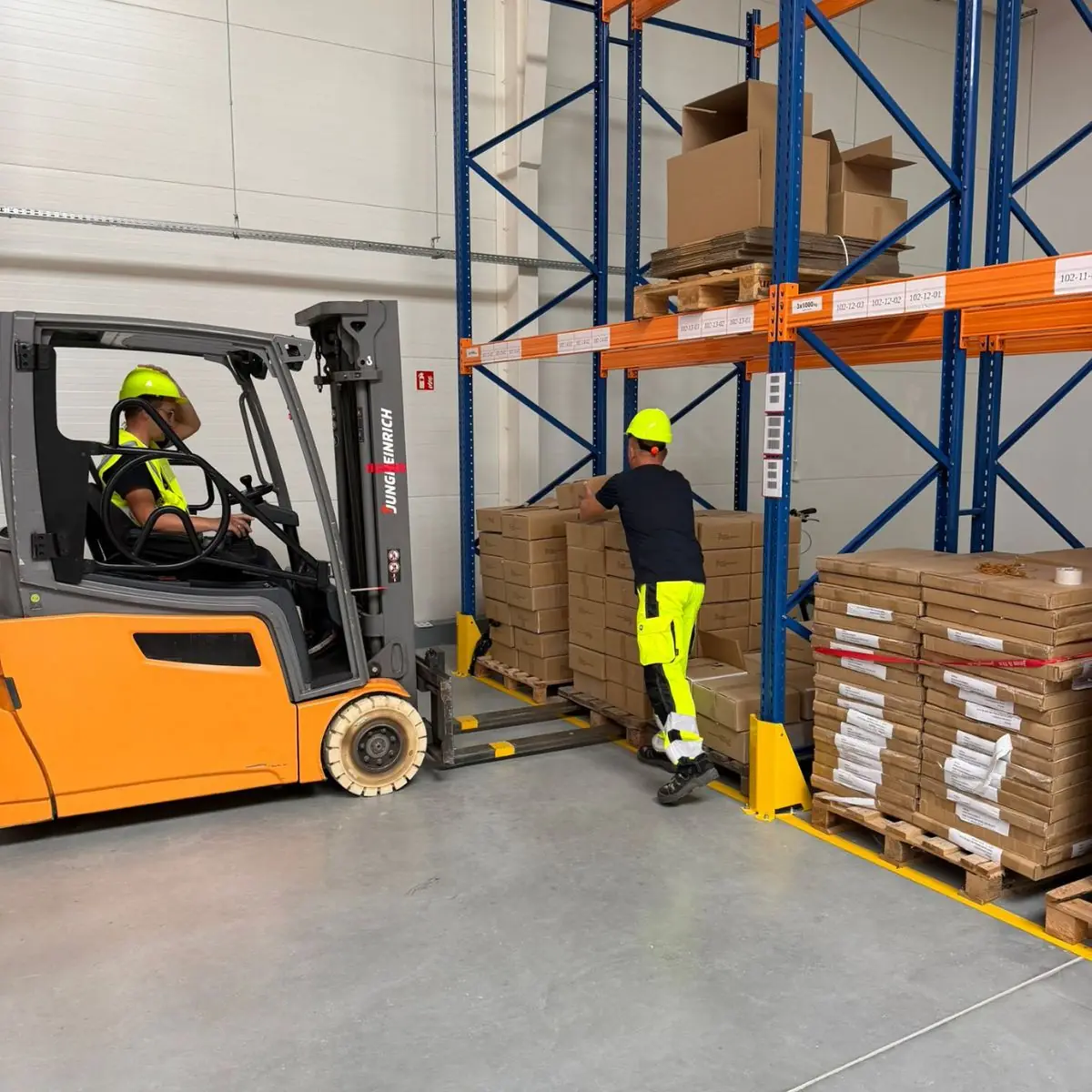 Mitarbeiter von MDO Logistics kommissionieren Kartons mit dem Gabelstapler